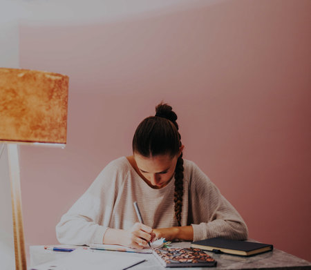 Focused college student studying at home by a cozy lamp