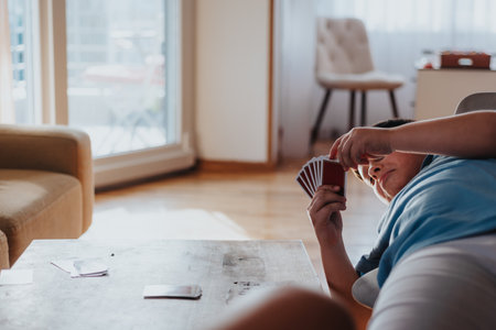 Boys playing card game at home, enjoying leisure time and building friendshipの写真素材