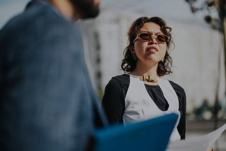 Professional woman outdoors holding documents in business meeting