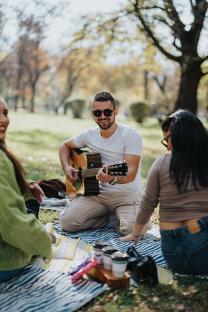 Group of young adults enjoying a sunny day in the park with live music and laughterの写真素材