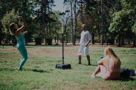Friends relax and play games in a scenic park setting, enjoying a casual day outdoors.