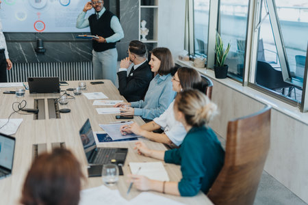 A diverse group of business people engage in a collaborative meeting, exchanging ideas and analyzing...