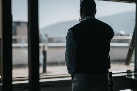 Businessperson gazing through office window contemplating future opportunities