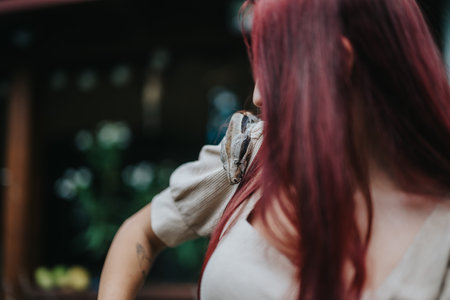 Girl with red hair and snake on shoulder in natural settingの写真素材