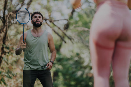 Young friends enjoying a fun badminton match in the parkの写真素材