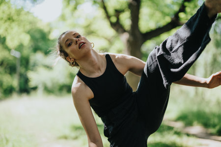 Gorgeous girl performing modern dance on a sunny day in an urban park