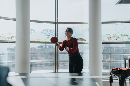 Business employee playing table tennis in modern office loungeの写真素材
