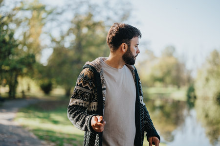 Casually dressed man enjoying a peaceful walk in the parkの写真素材