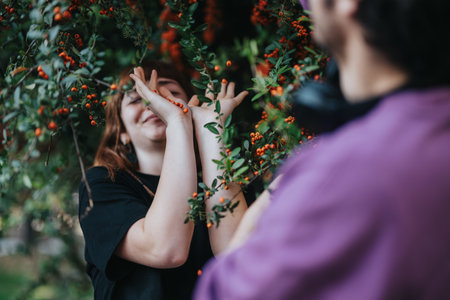 Joyful woman enjoying nature surrounded by berry branches outdoorsの写真素材
