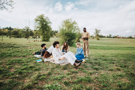 Group of friends enjoying a peaceful picnic in a grassy fieldの写真素材