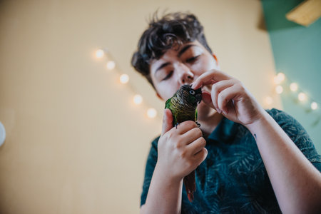 Young girl interacting with her pet parrot at homeの写真素材