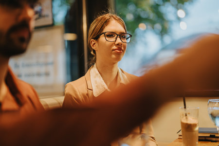Young people engaged in a lively business meeting at a cafeの写真素材