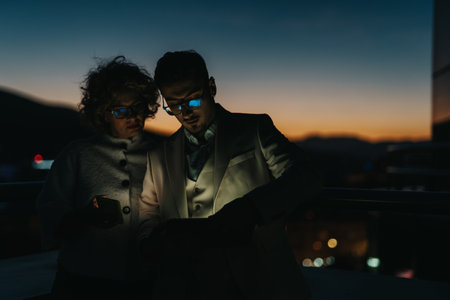 Businesspeople brainstorming at night on an outdoor balcony during sunset
