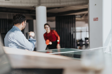 Casual office ping pong game between business coworkers