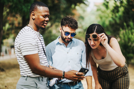 Group of young business people interacting outside with smart phoneの写真素材