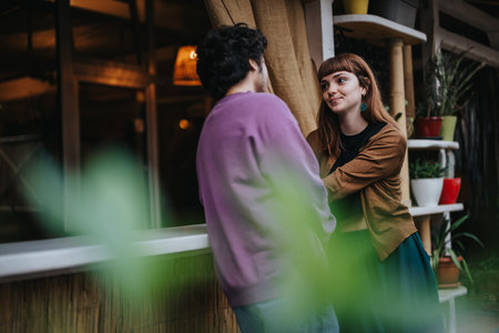 Friendly conversation between two people in a cozy cafe settingの写真素材