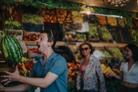 Friends enjoying buying fruits and vegetables at local greengrocerの写真素材