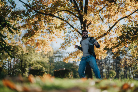 Man enjoying nature in colorful autumn park with vibrant leavesの写真素材