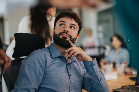 Pensive business worker in a busy office environmentの写真素材