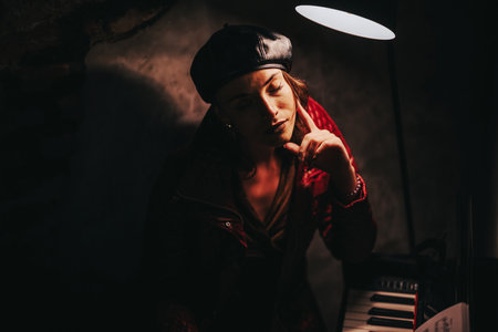 Pensive woman in dimly lit room with piano and lampの写真素材