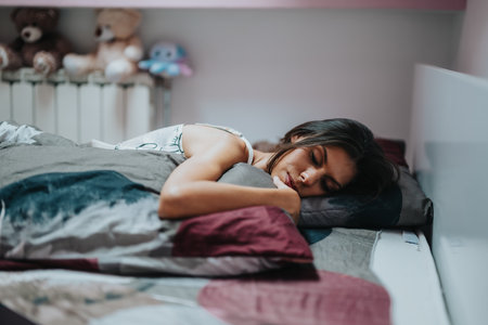 Peaceful young woman sleeping in cozy bedroom interiorの写真素材