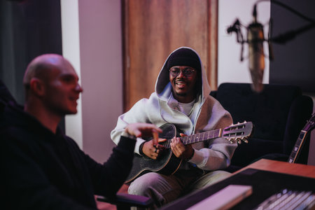 Two musicians collaborate in a modern recording studio with guitar and microphone