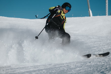 Skier Enjoying a Thrilling Ride Down a Snowy Slope During Winter