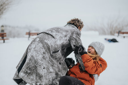 Joyful Moment of Friends Enjoying a Winter Snowball Fight Outdoorsの写真素材