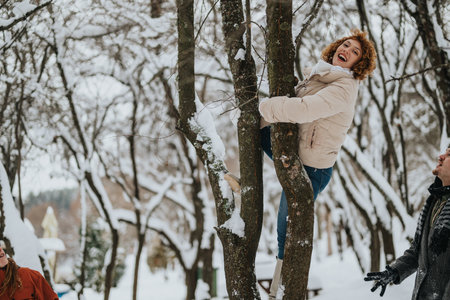 Friends enjoying a playful winter day with laughter and snowy outdoor activitiesの写真素材