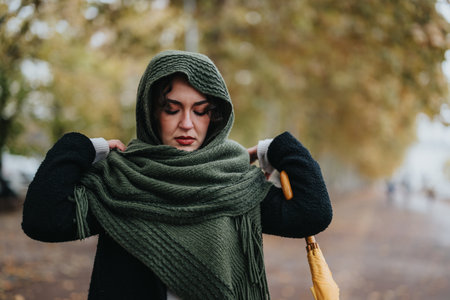 Woman wearing a cozy scarf outdoors on an autumn dayの写真素材