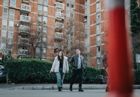 Two friends walking casually in an urban city neighborhood street