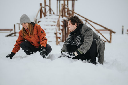 Two friends enjoying winter outdoors playing in snow with fun and laughter