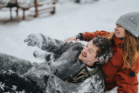 Joyful couple enjoying playful winter moments together outdoors in snowy weather