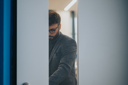 Professor in a professional outfit entering a classroom through doorの写真素材