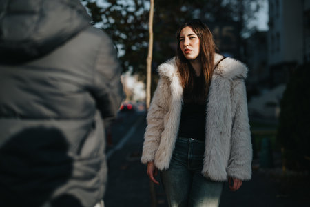 Young woman in a fur jacket strolling through an urban street sceneの写真素材