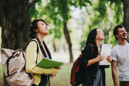 Multicultural students enjoying a collaborative study session in the parkの写真素材