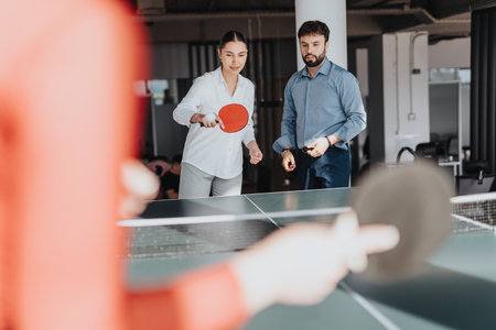 Business colleagues enjoy a friendly game of table tennisの写真素材