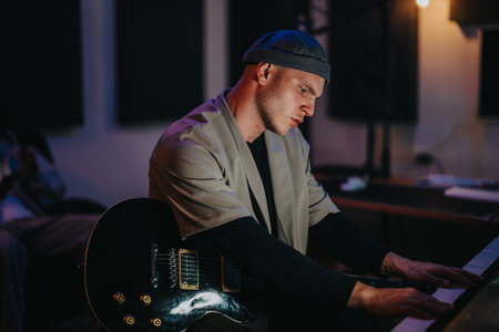 Musician playing piano passionately in a dimly lit music studioの写真素材