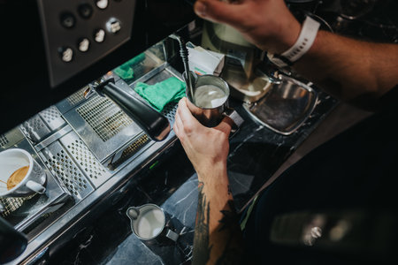 Barista preparing steamed milk for coffee in a modern espresso machine station