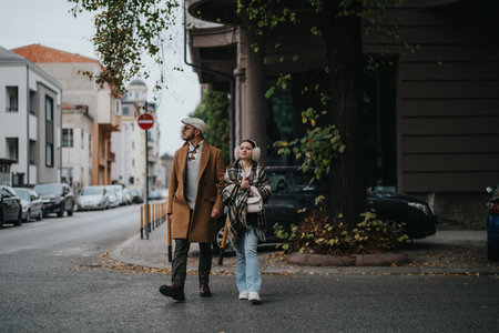 Stylish young couple strolling through city streets on a chilly dayの写真素材