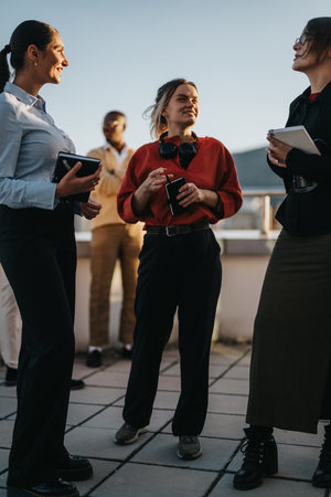 Multiracial business team brainstorming on a high-rise balcony at sunsetの写真素材