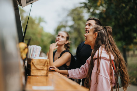 Group of Friends Ordering at Outdoor Food Truck in Parkの写真素材