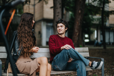 Young friends enjoying a casual conversation on a park bench