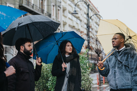 Diverse group discussing ideas under umbrellas on a rainy city day