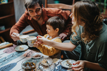 A family enjoying tea together around a beautifully set table, sharing a warm and joyful momentの写真素材