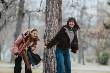 Two Friends Laughing Together Outdoors in an Autumn Forestの写真素材
