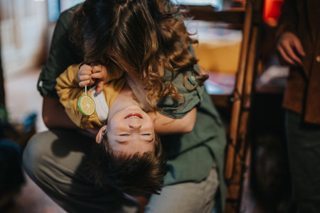 Playful family moment featuring a young child laughing while being held upside-down