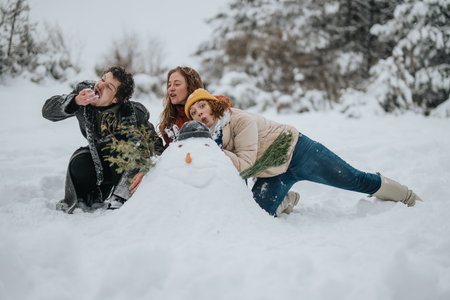 Friends making a playful snowman together in a snowy park during winter