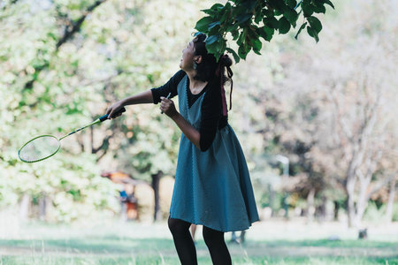 Young woman enjoying a lively game of badminton in the park