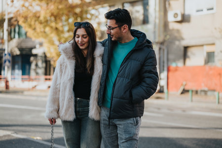 Couple walking together in urban setting on a sunny dayの写真素材
